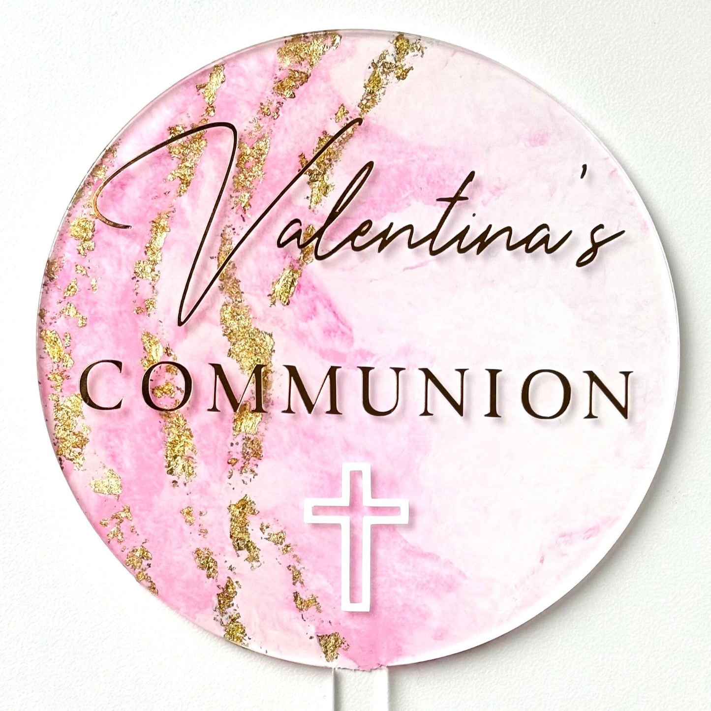 Round pink and gold marbled cake topper with 'Valentina's Communion' text on a white background