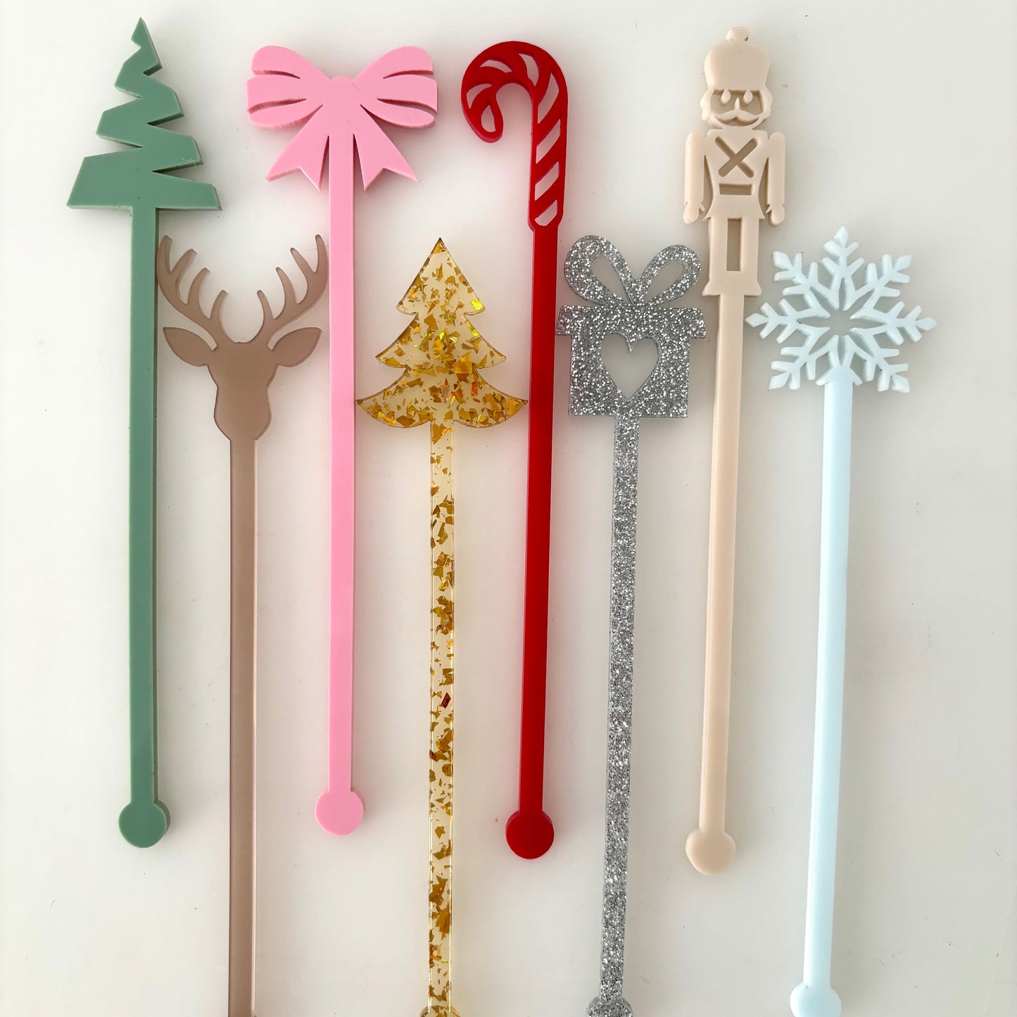 Set of decorative stir sticks with various designs on a white background