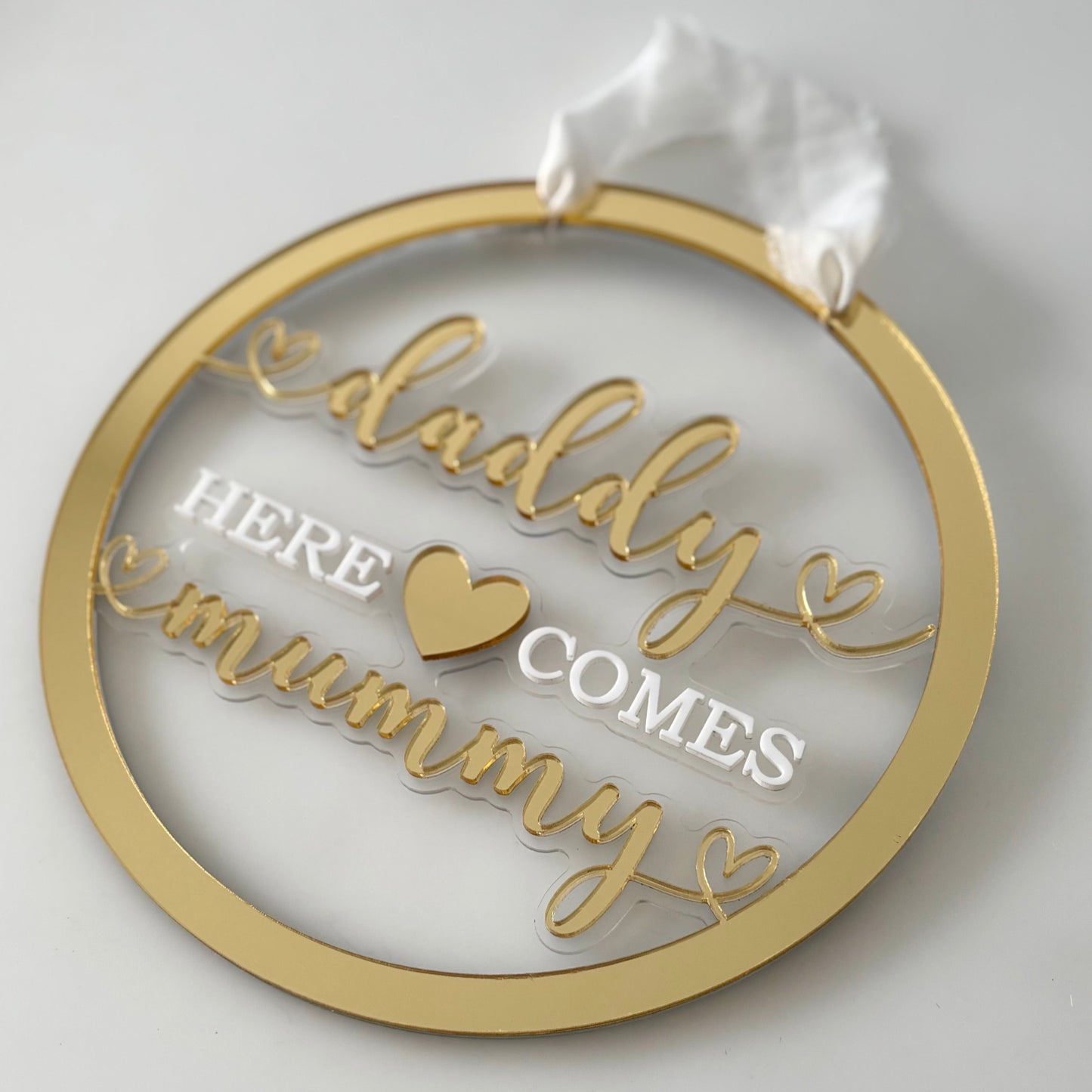 Decorative wedding sign with 'daddy here comes mummy' text on a white background