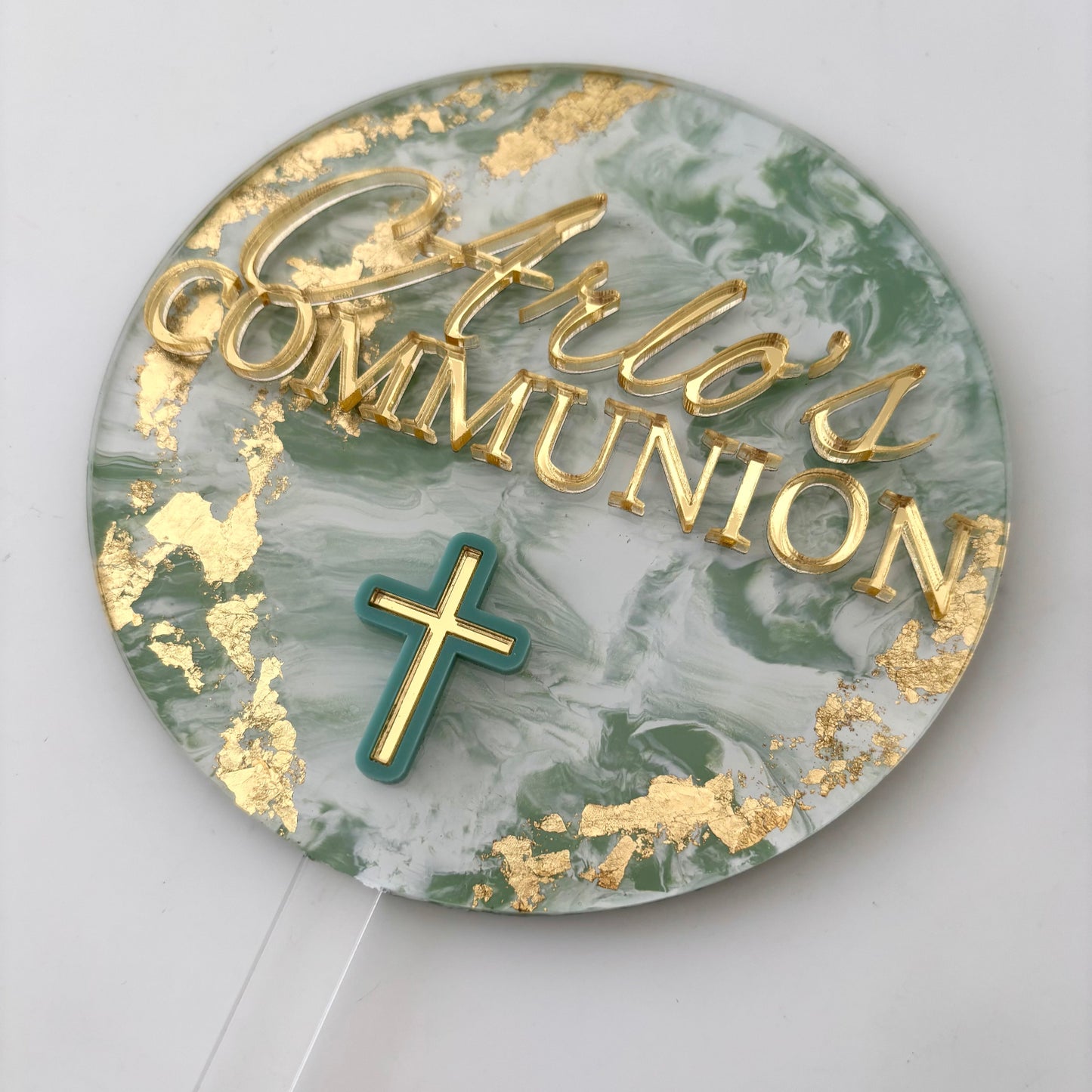 Round cake topper with 'Arlo's Communion' text and a cross on a marble pattern background