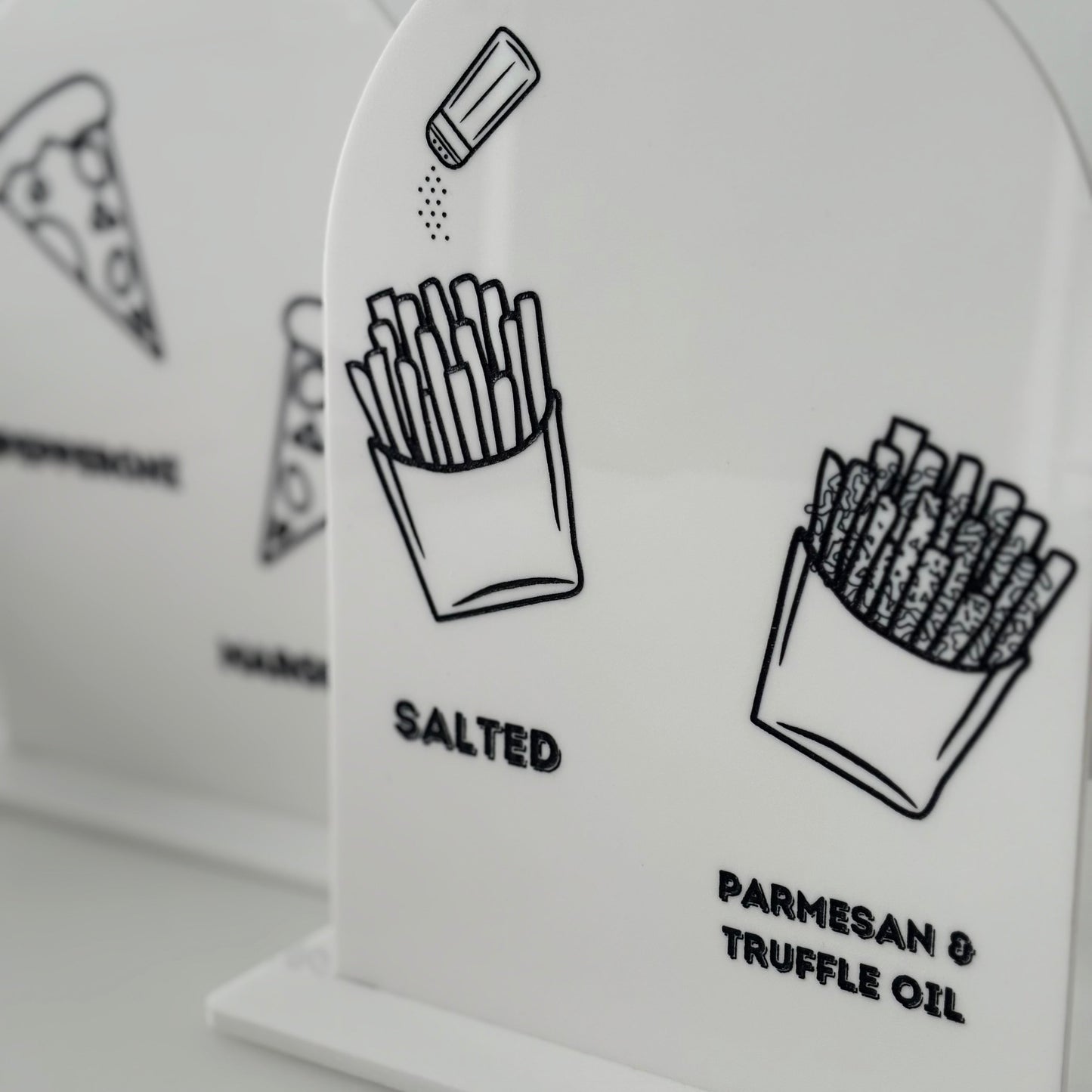 White salt and pepper shakers with black illustrations and text on a light gray background