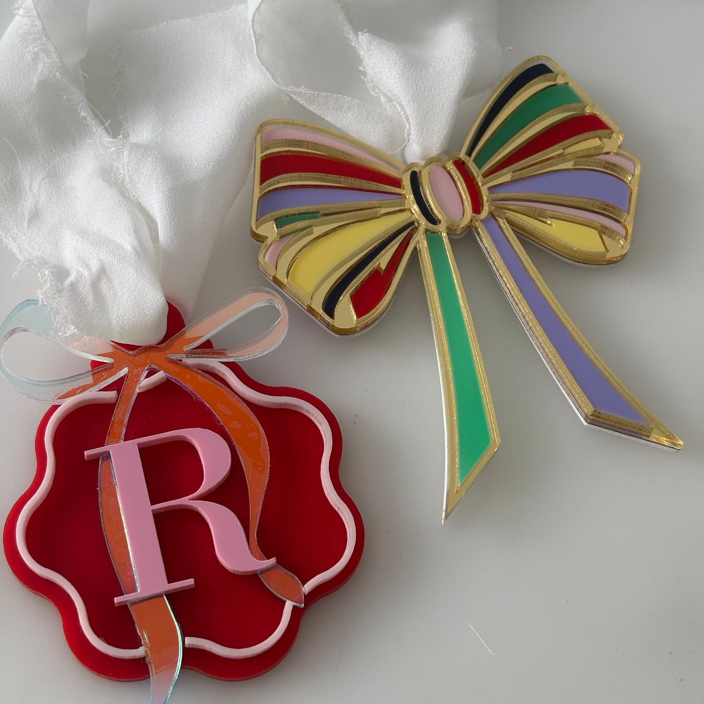 Colorful bow-shaped Christmas ornament with multi coloured stripes on a white background