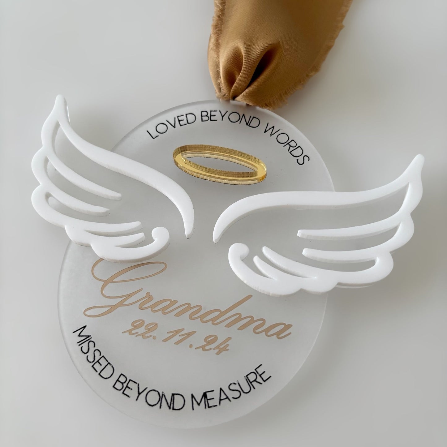 Memorial Christmas ornament with angel wings and text on a white background