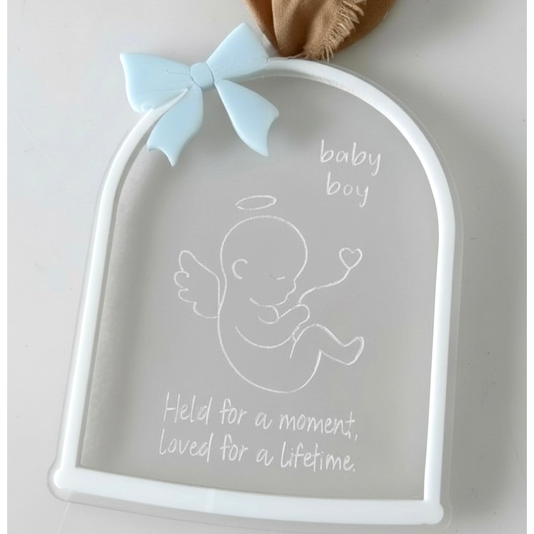 Decorative plaque with baby boy design and text on a light background