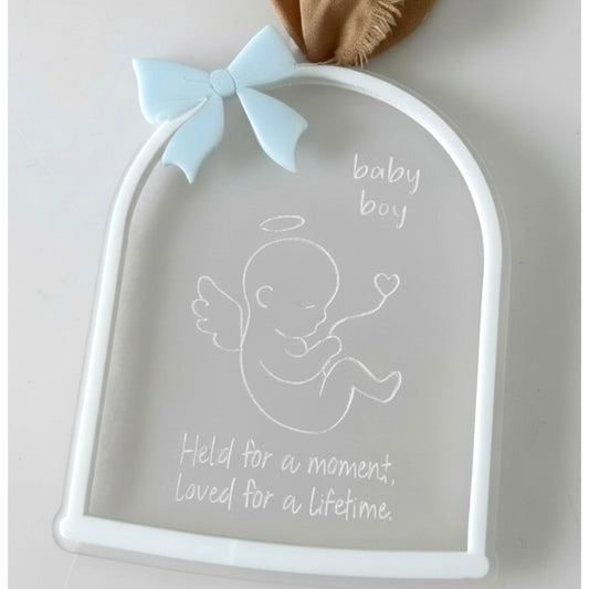 Decorative plaque with baby boy design and text on a light background