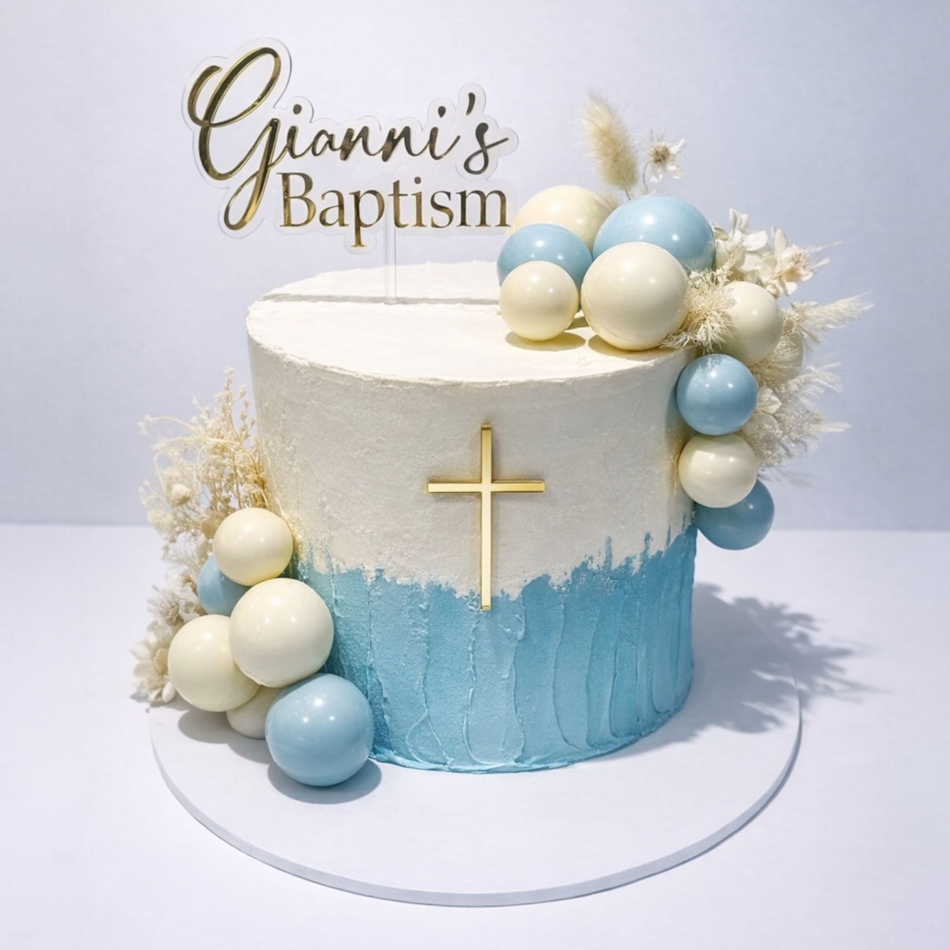 Baptism cake with blue and white design, decorative elements, and 'Gianni's Baptism' text.