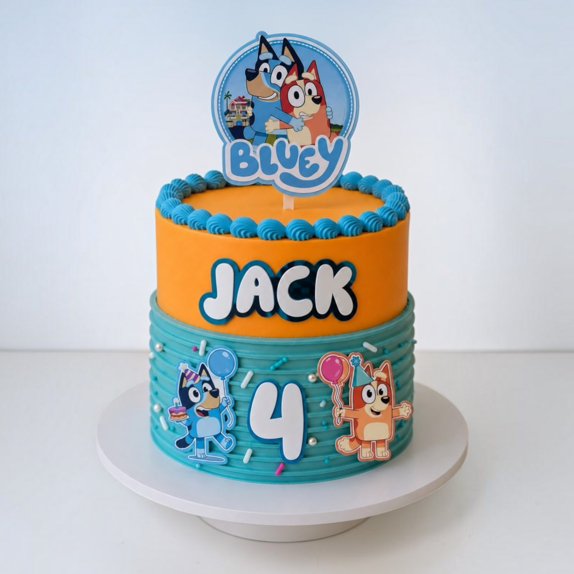 Personalised Bluey cake topper with custom name Jack, age 4 and matching Bluey acrylic cake side charms on a birthday cake.