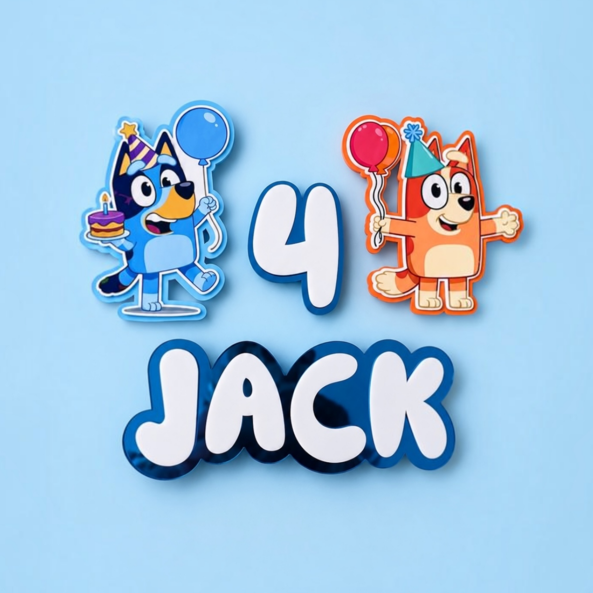 Custom acfrylic lettering and characters for a child's birthday cake, featuring Bluey's character Jack holding a party hat and balloon, the number 4, and the name 'JACK' in bold white letters with blue shadows, all on a light blue background.