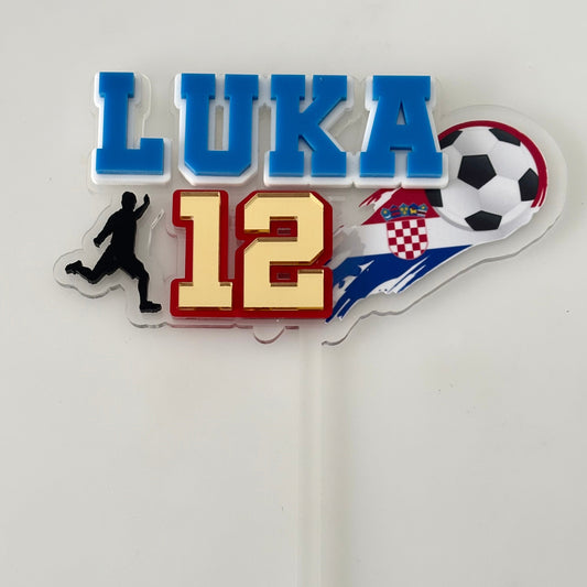 Personalised soccer-themed name and number cake topper with a player silhouette, soccer ball, and Croatian flag on a clear background.
