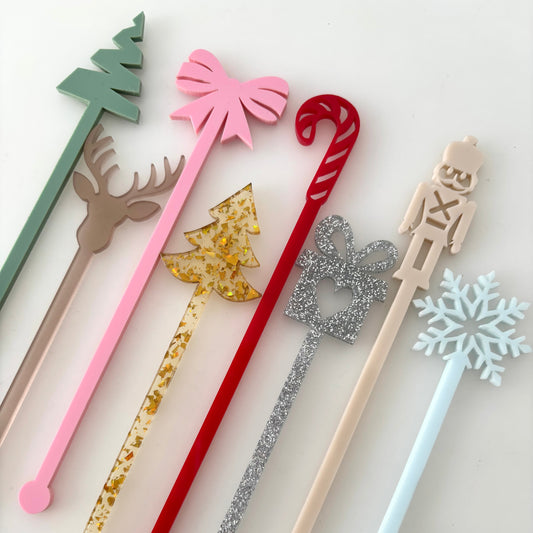 Set of decorative stir sticks with festive designs on a white background