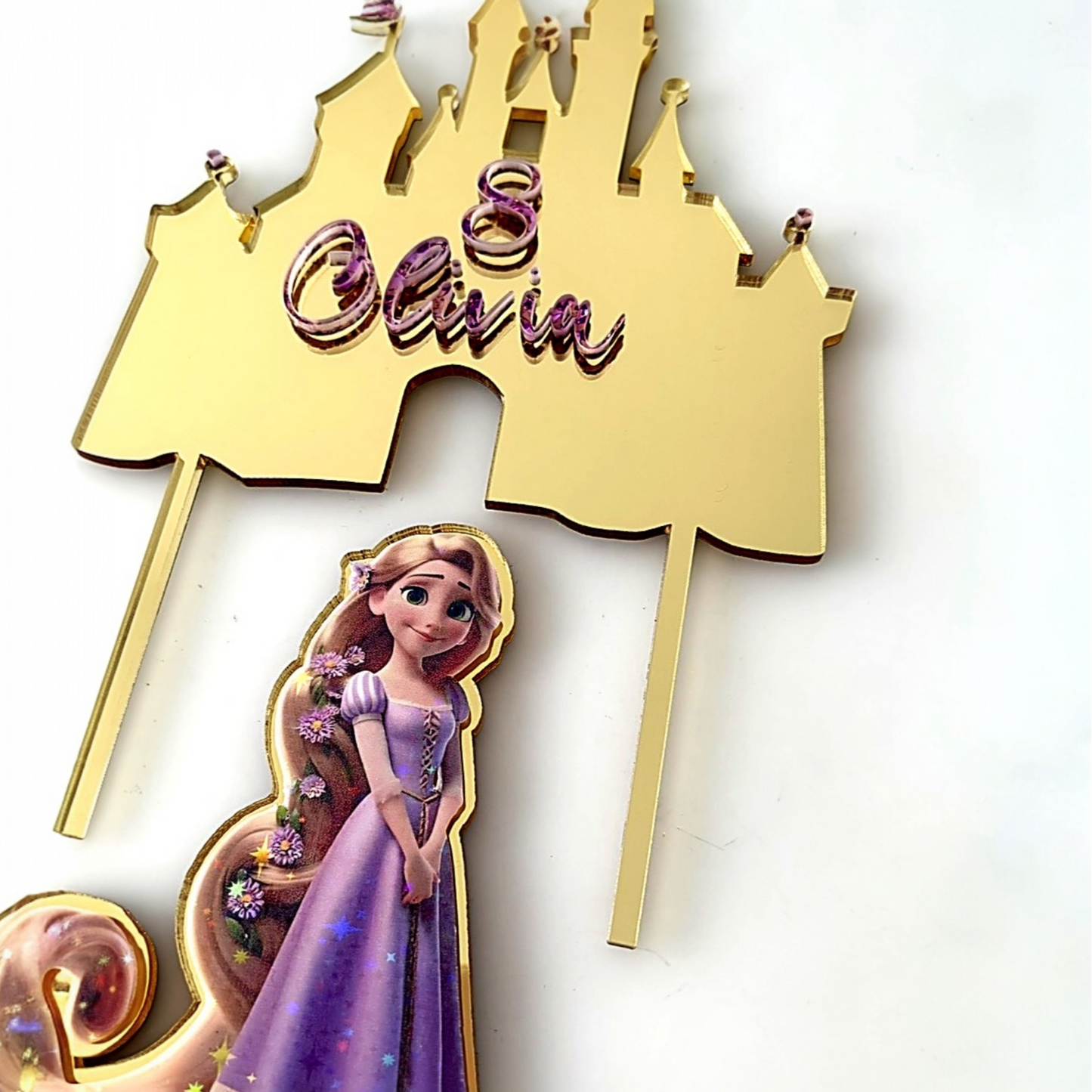 Gold castle-shaped number 7 with a disney princess Rapunzel figure on a cake.
