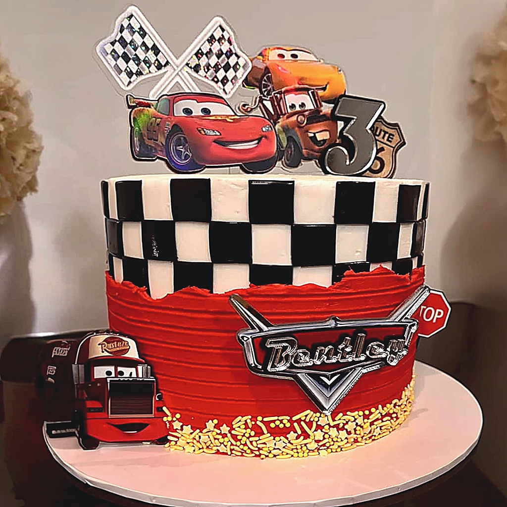 Cake with Disney Cars theme cake topper set, featuring characters and checkered pattern