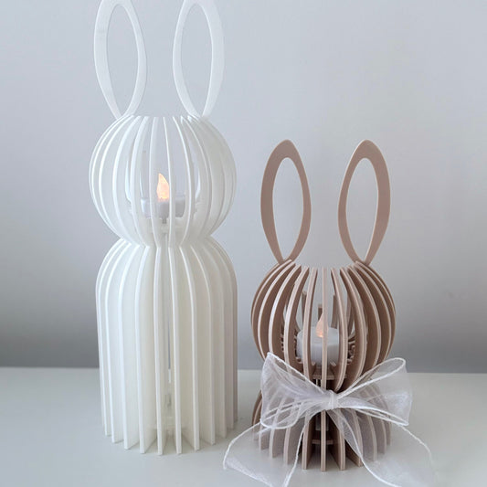 Two decorative rabbit-shaped candle holders on a white surface with a light gray background.