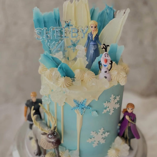 Frozen-themed birthday cake with characters and decorations on a neutral background