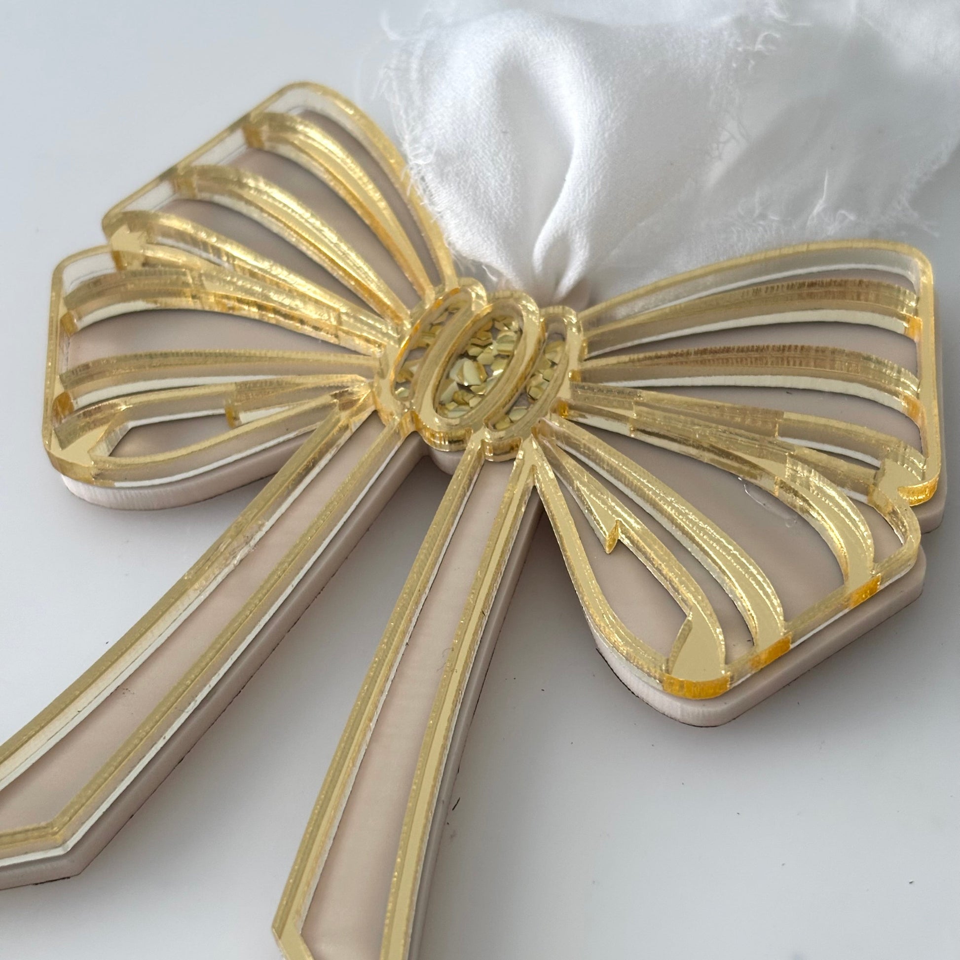 Gold bow-shaped decorative item on a white background