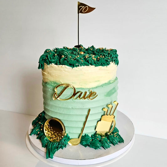 Golf-themed birthday cake with gold cake topper set on a white background