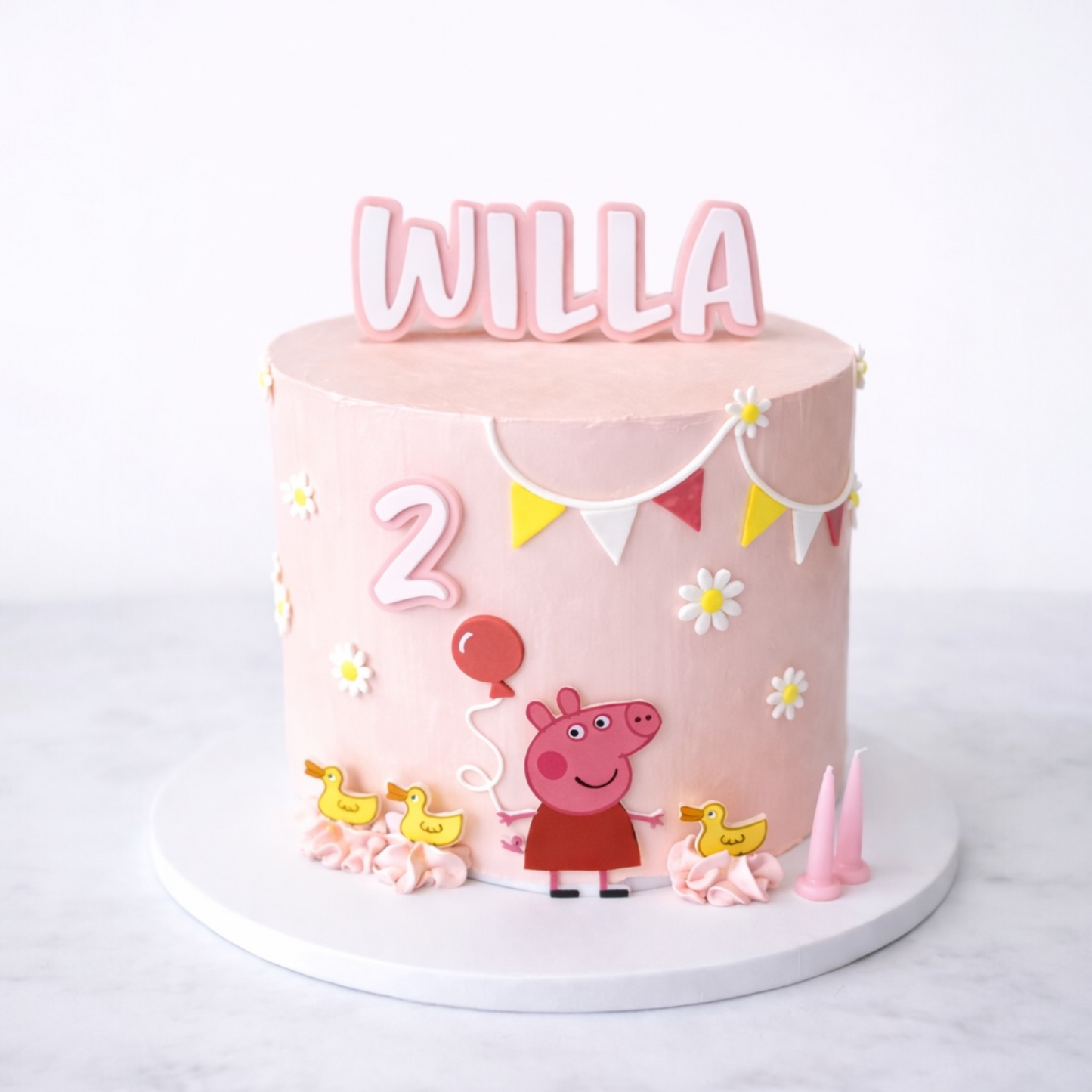 Pink birthday cake with 'Willa' and number '2' on a white background