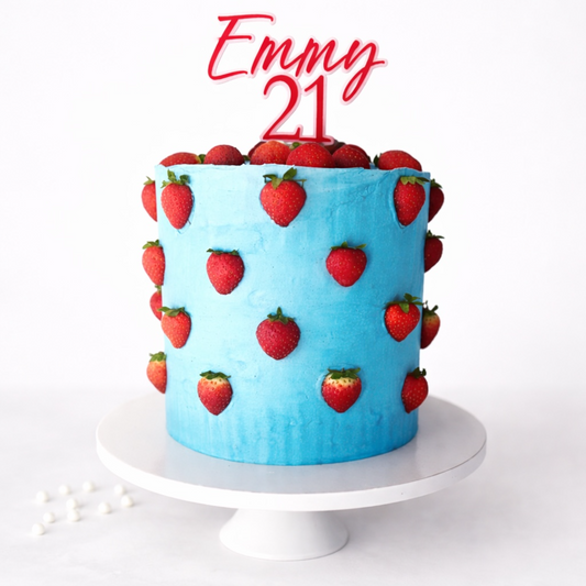 Blue cake with strawberry decorations and 'Emmy 21' on a white background