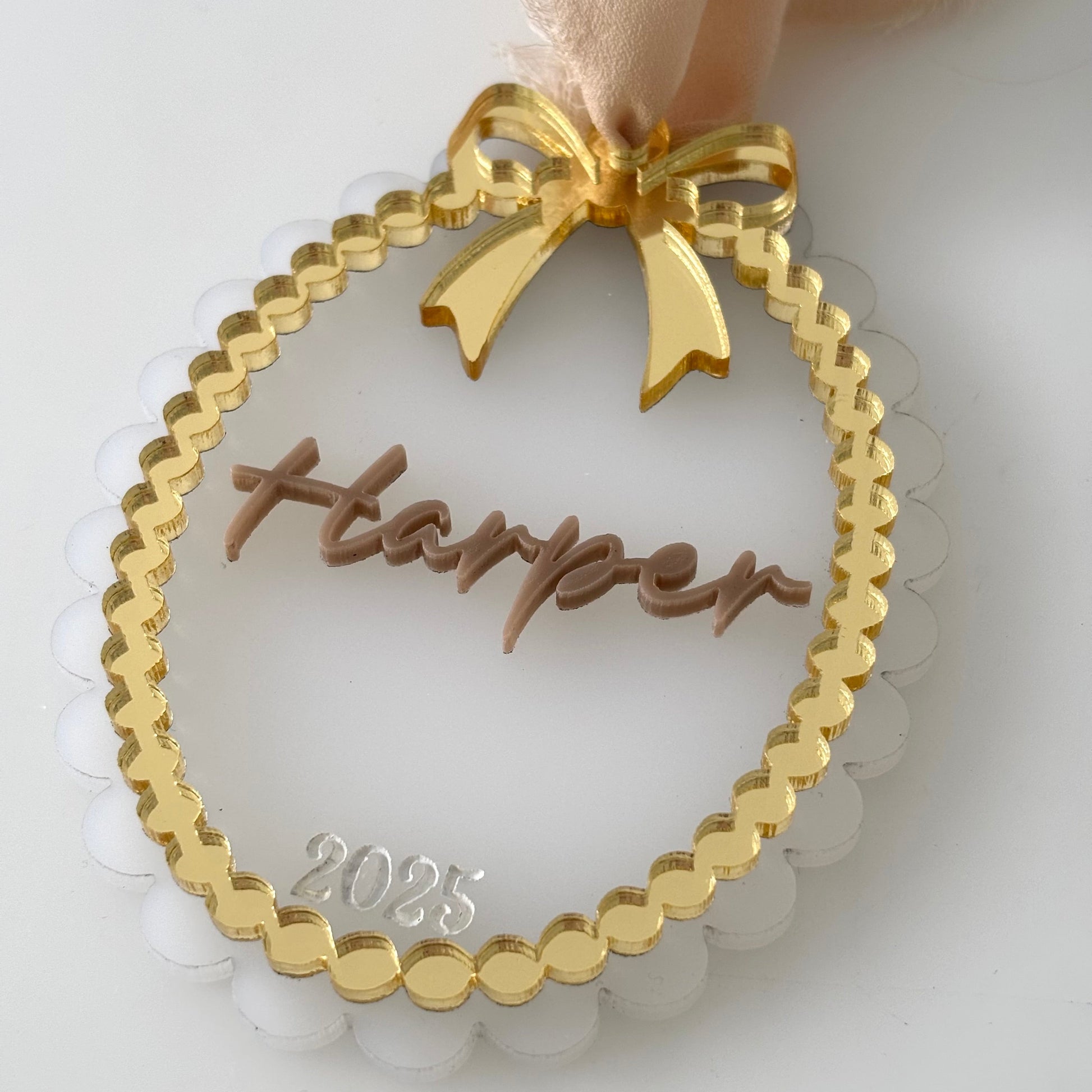 Gold ornament with 'Harper' and '2025' on a white background