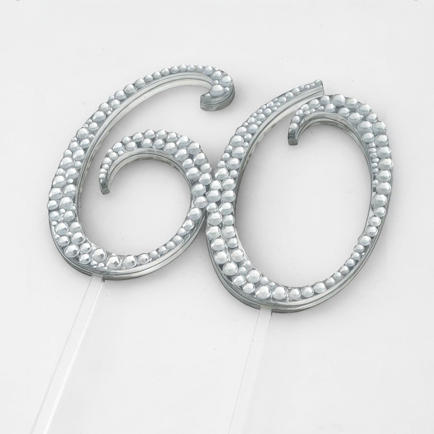 Silver cake topper with '60' design on a white background
