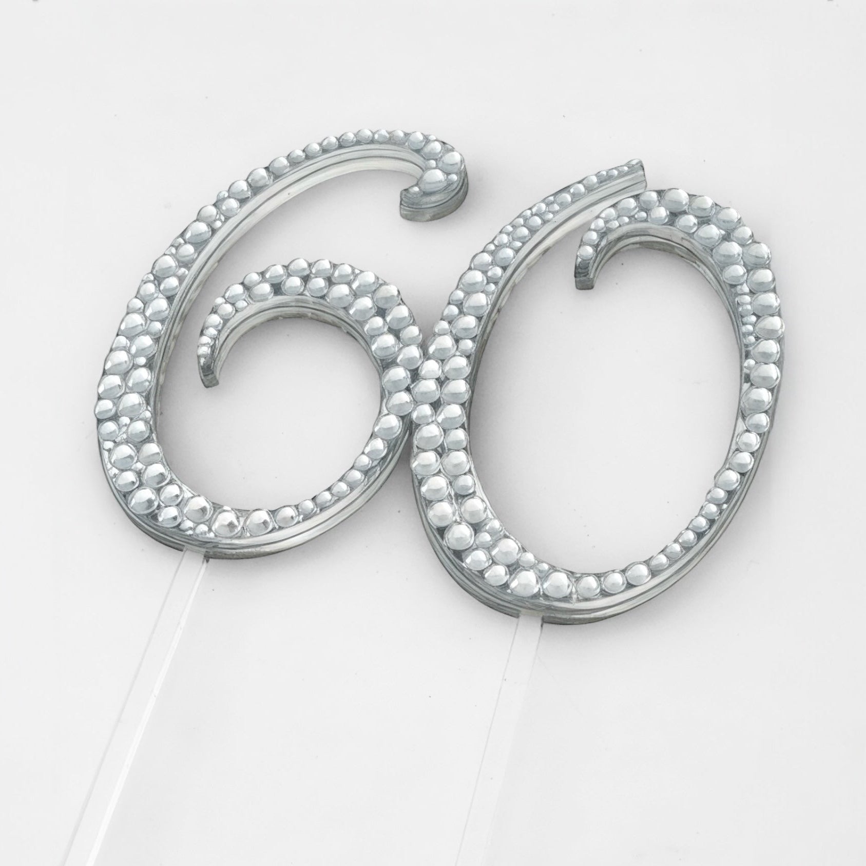 Silver cake topper with '60' design on a white background