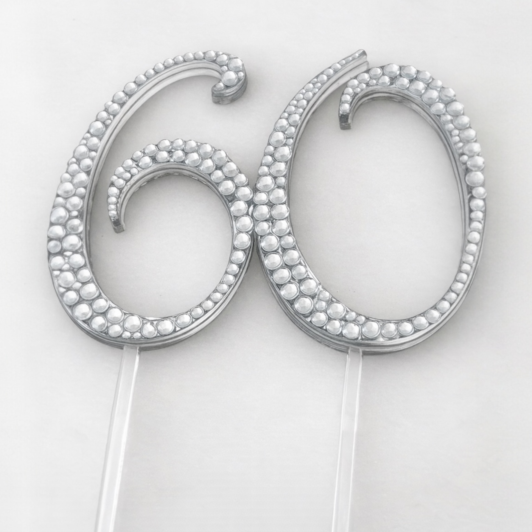 Silver cake topper with '60' design on a white background