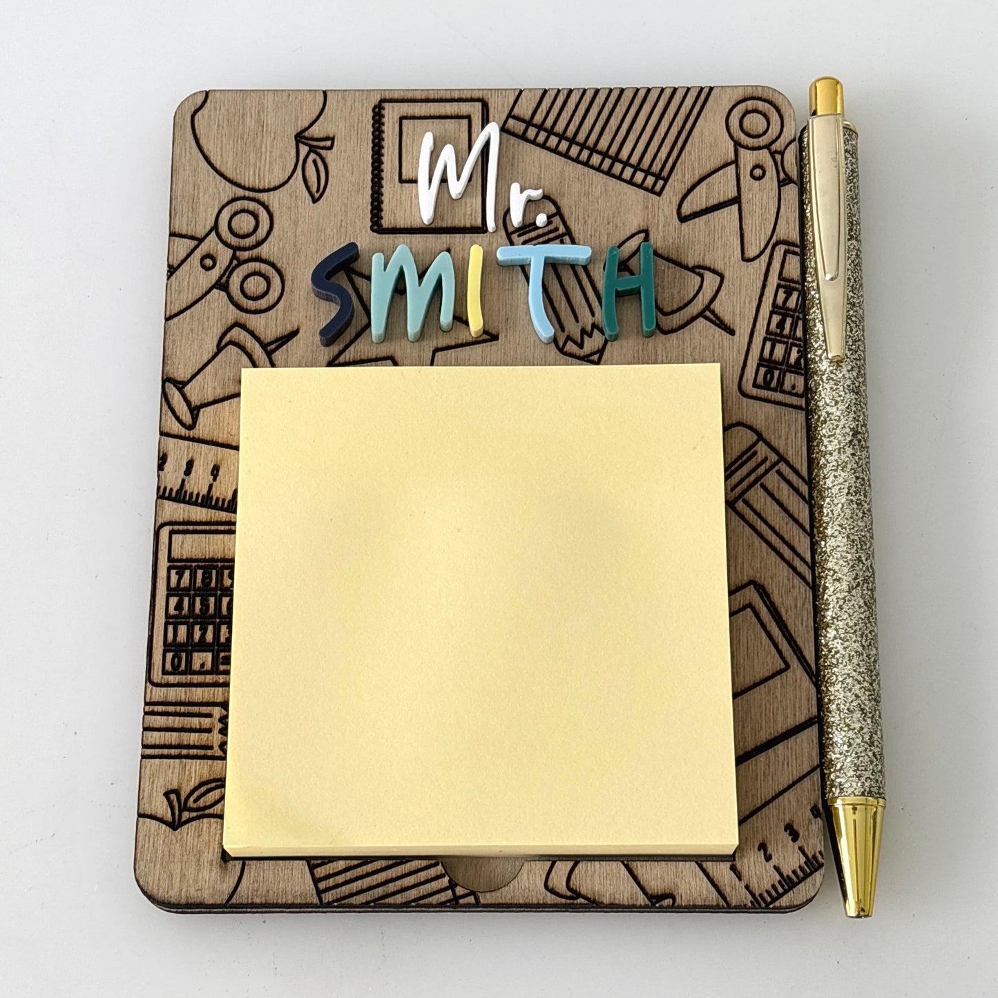 Notebook with 'Mr Smith' personalized name, sticky notes, and a pen on a white background