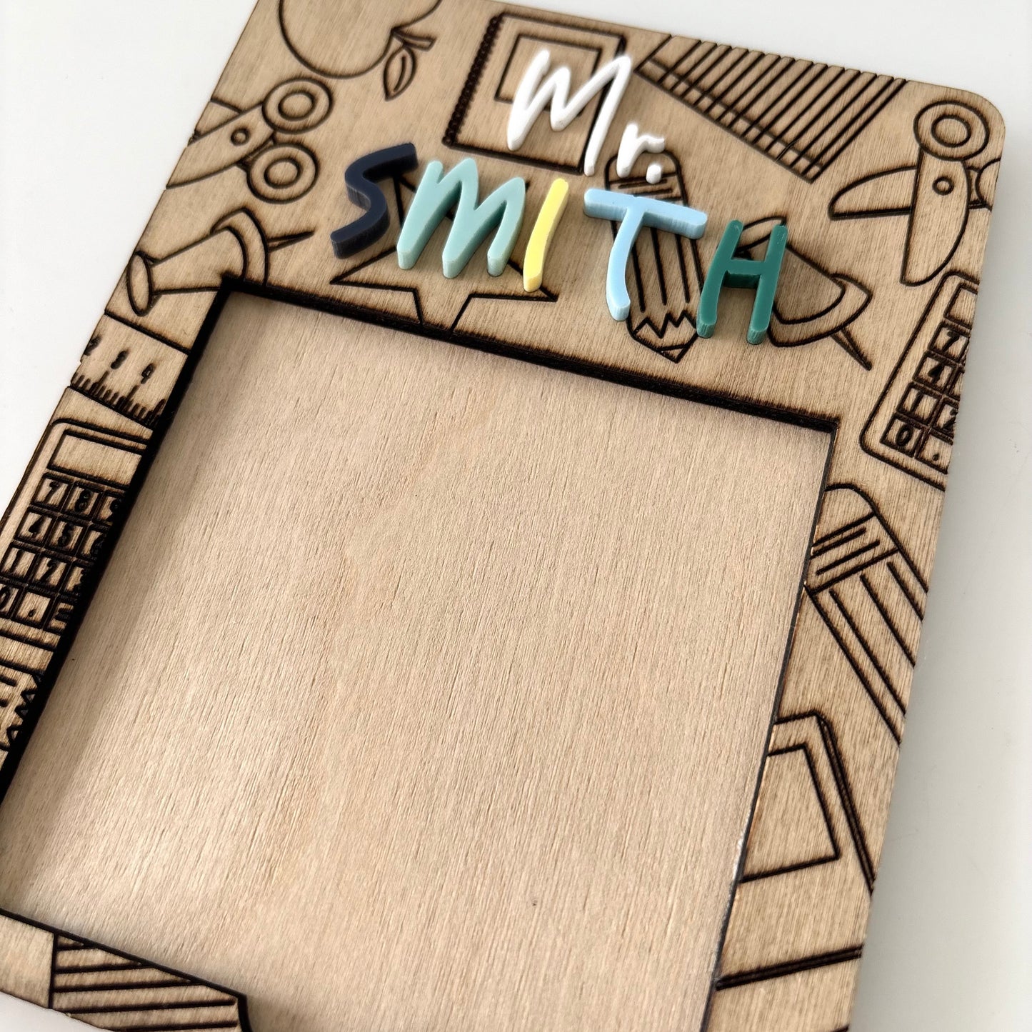 Wooden sticky note holder with 'Mr. Smith' text and doodle designs on a white background