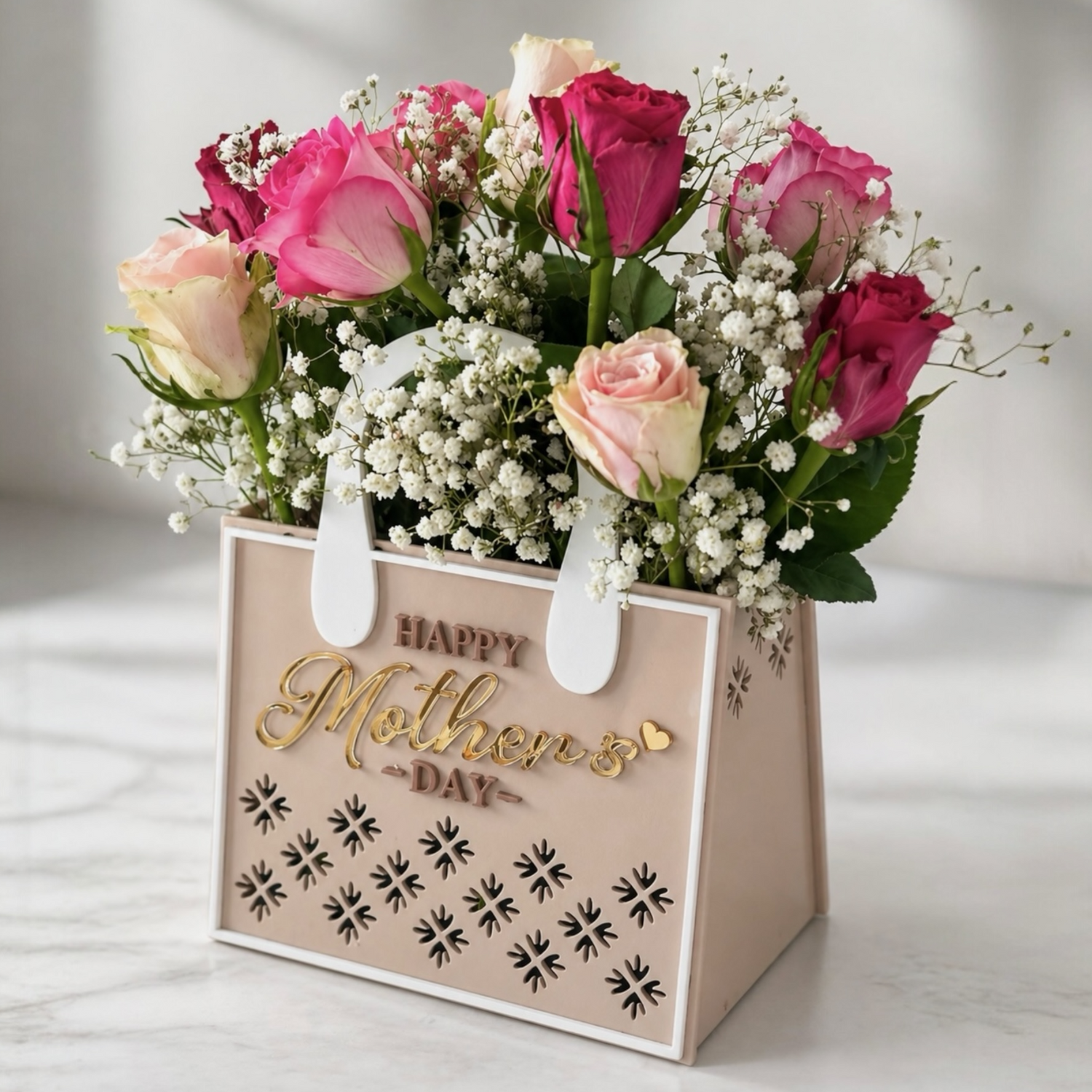 Floral arrangement in a 'Happy Mother's Day' gift bag on a light surface.