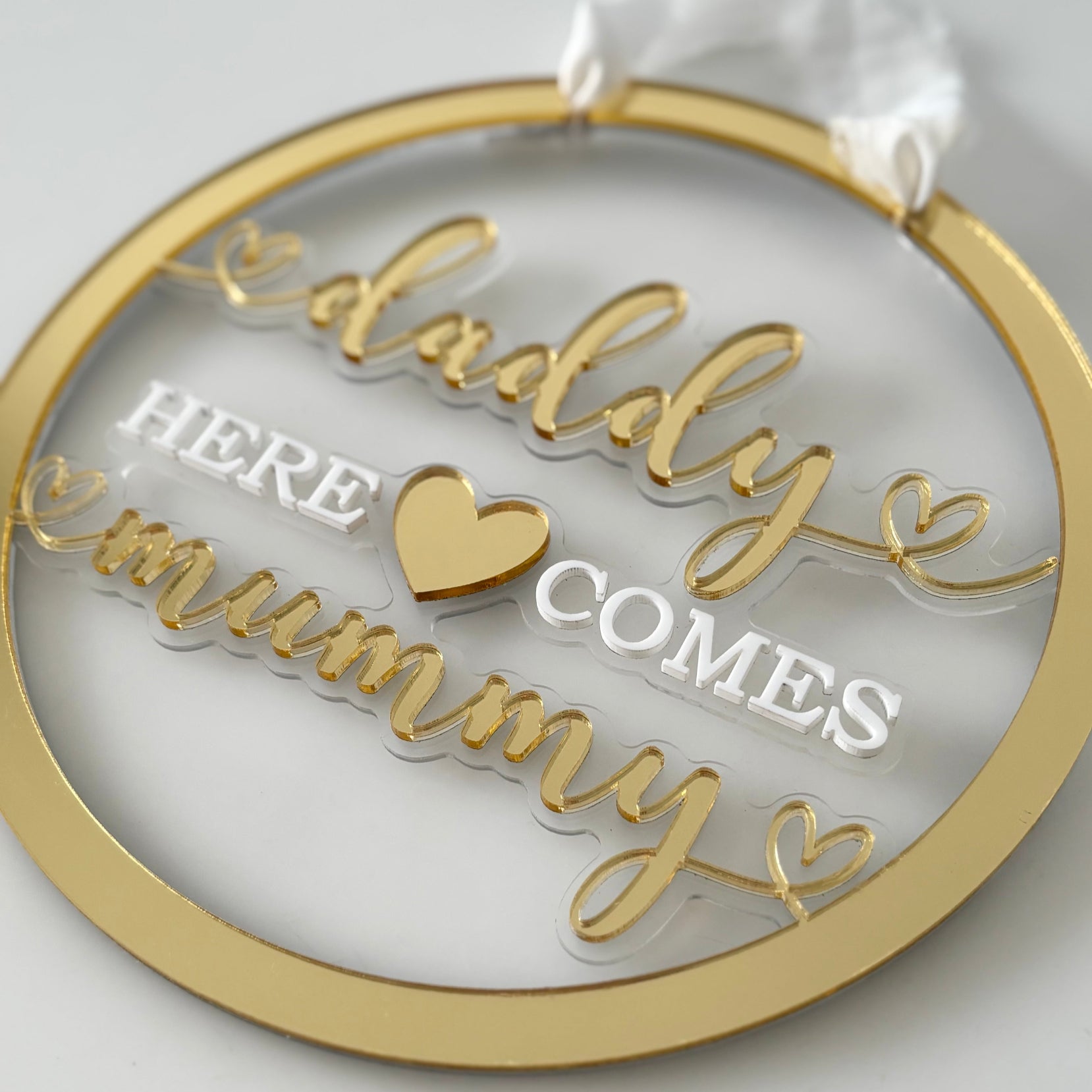 Decorative wedding sign with 'Daddy here comes mummy' text on a white background