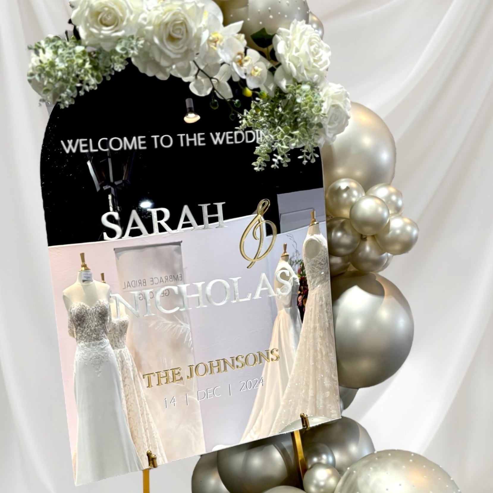 Wedding welcome sign with balloons and floral decorations on a white background