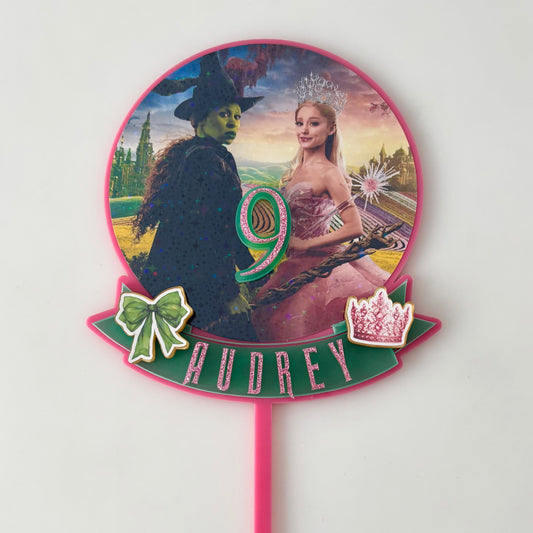 Decorative cake topper with characters from 'The Wizard of Oz' on a white background