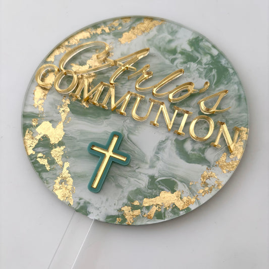 Round cake topper with 'Arlo's Communion' text and a cross on a marble pattern background